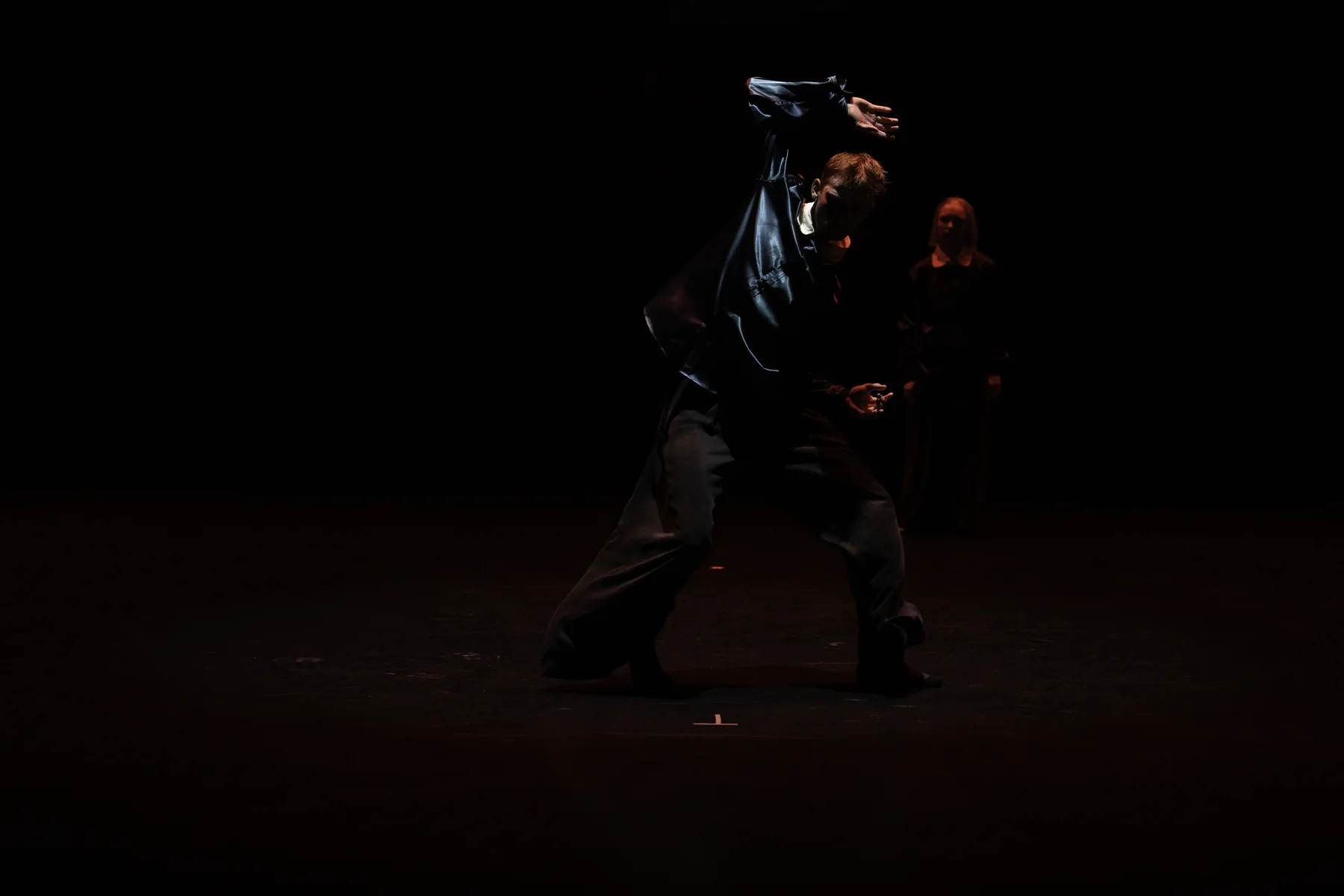 Jeffrey and an ensemble performing in a dark theater