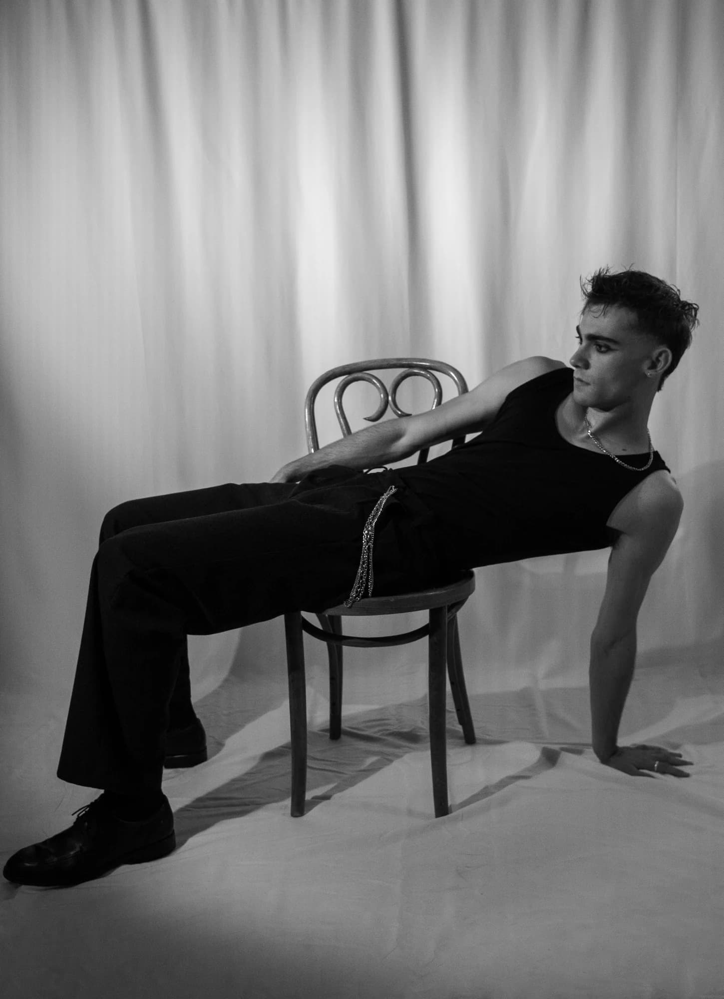Jeffrey reclining across a chair in a black-and-white portrait
